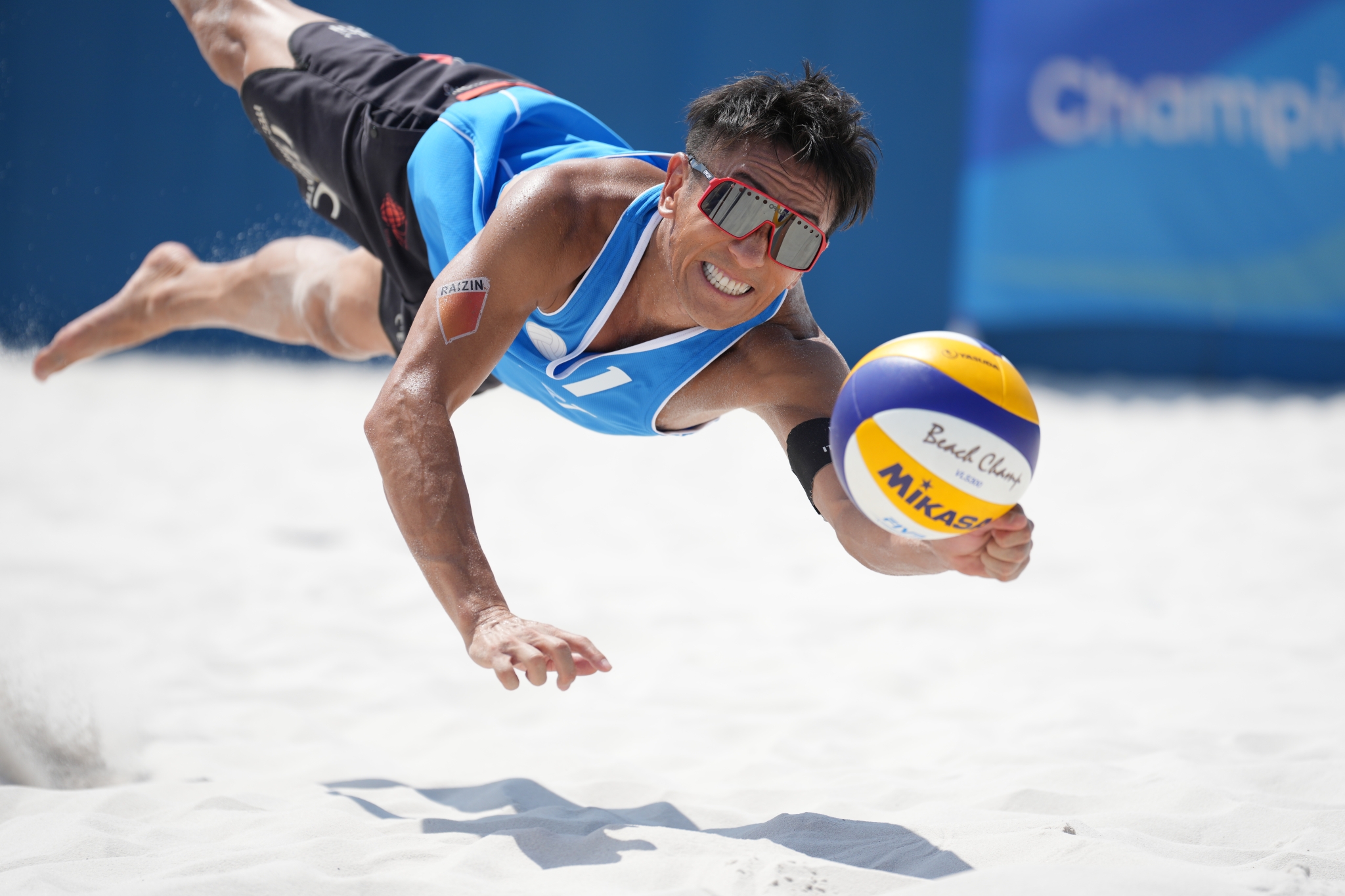 Male volleyball player diving for a ball