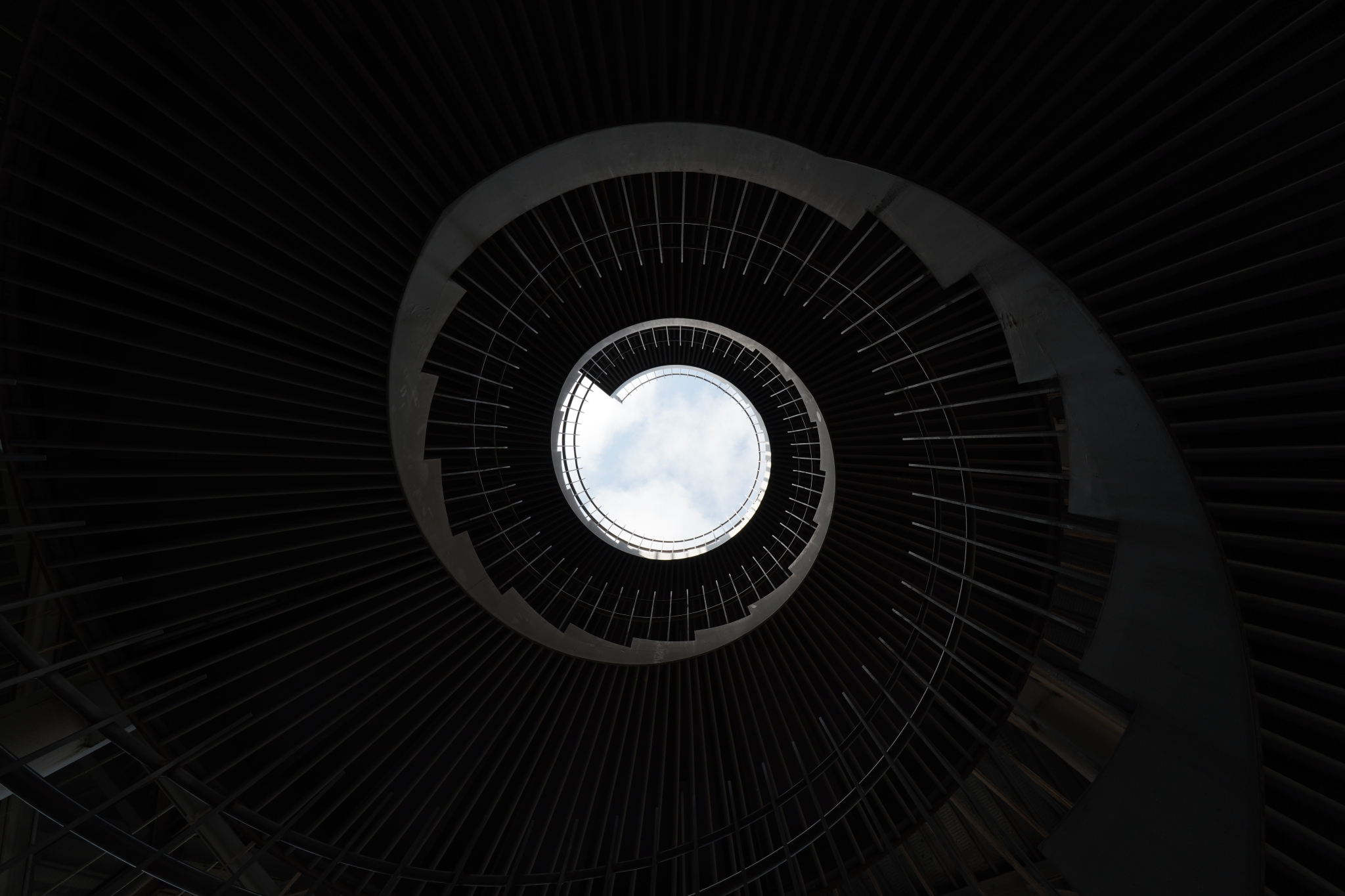Upwards shot of a spiral staircase and a circle of sky