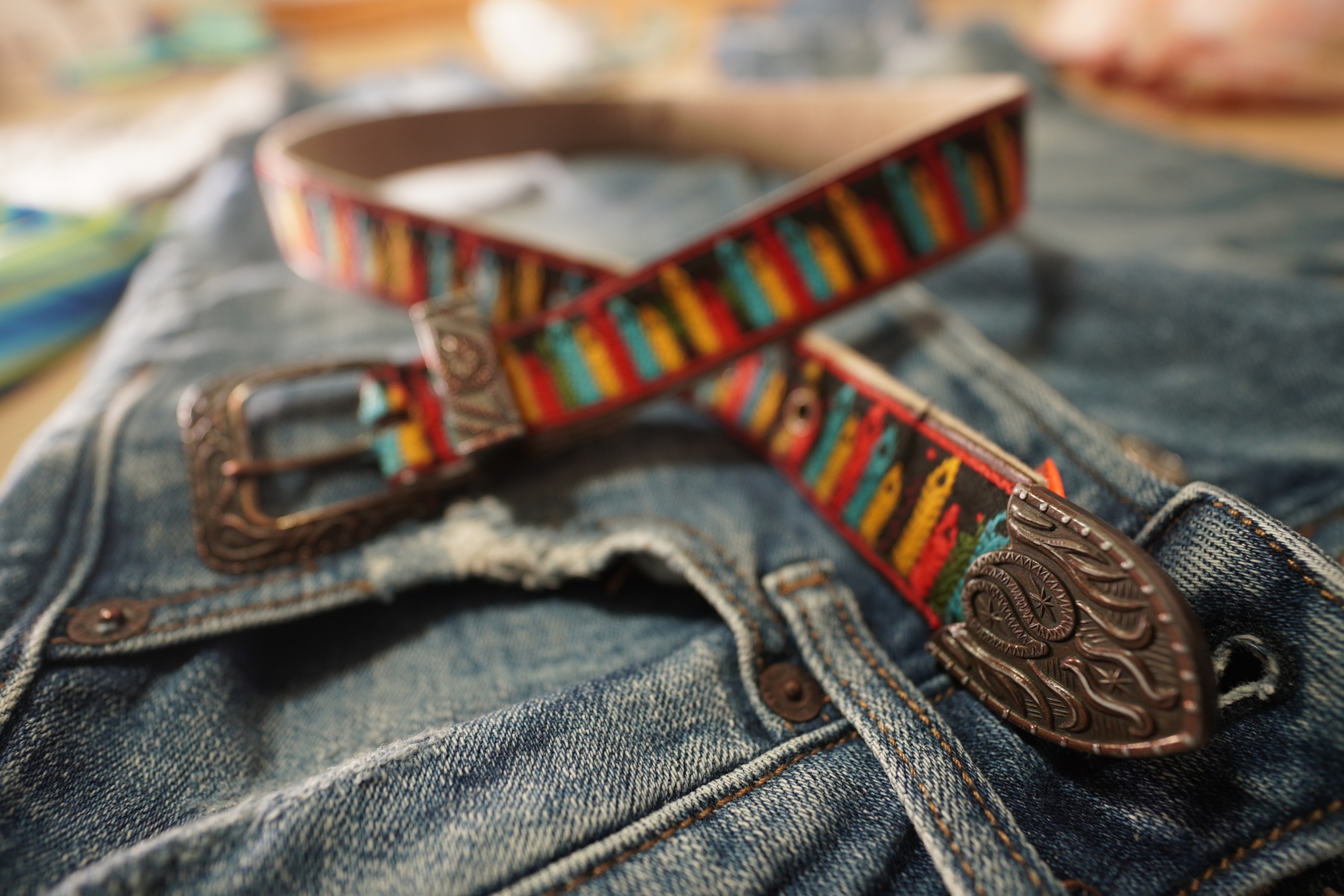 Close-up of a multi-coloured bracelet atop denim clothing