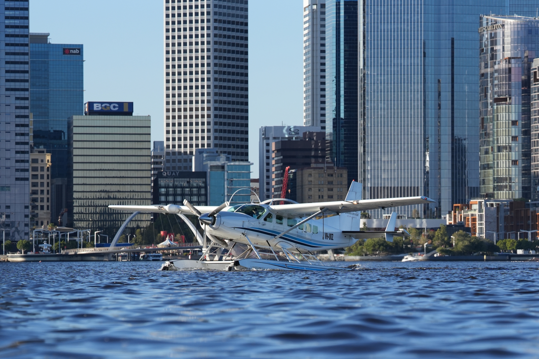 Plane taking off from water with a cityscape in the background