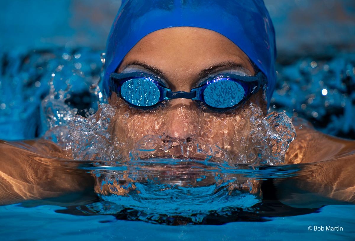 Frontal portrait of swimmer with goggles approaching the camera
