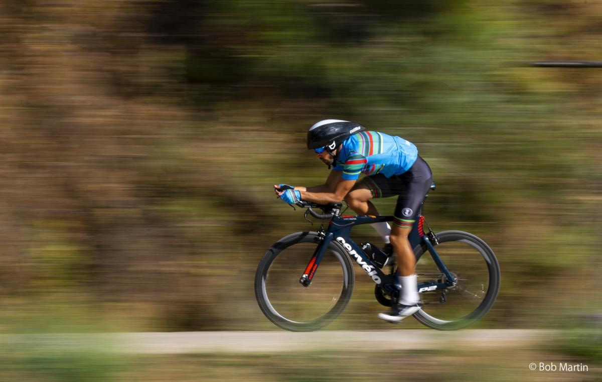 Profile view of competition cyclist at speed with background motion blur