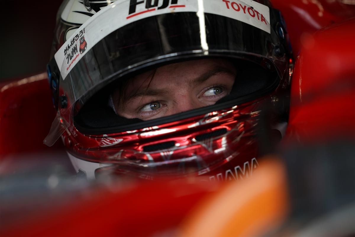 Close-up of racing driver with eyes visible through helmet visor