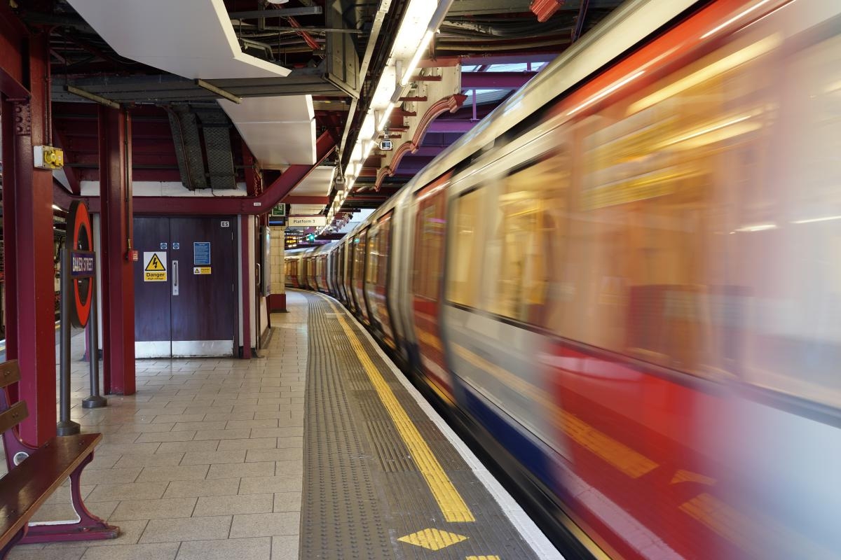 London Underground train pulling away from station with motion blur