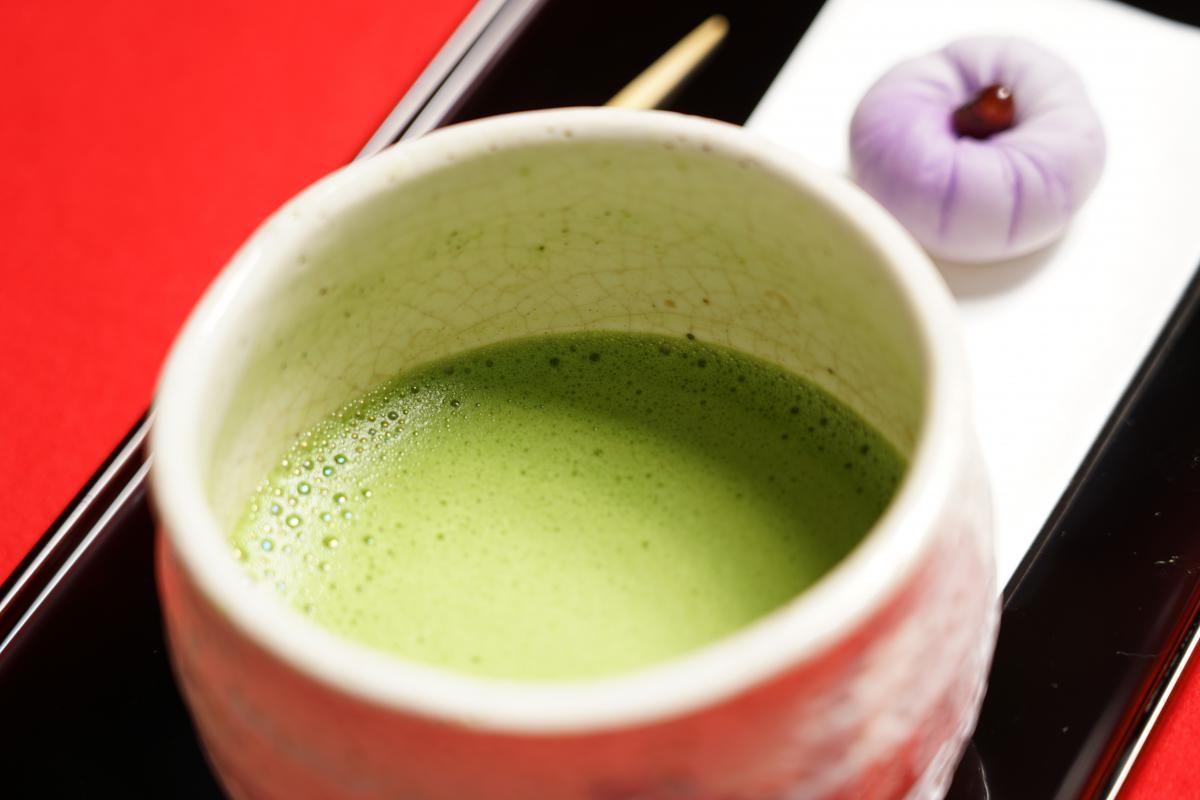 Close-up of matcha green tea with Japanese sweet in the background