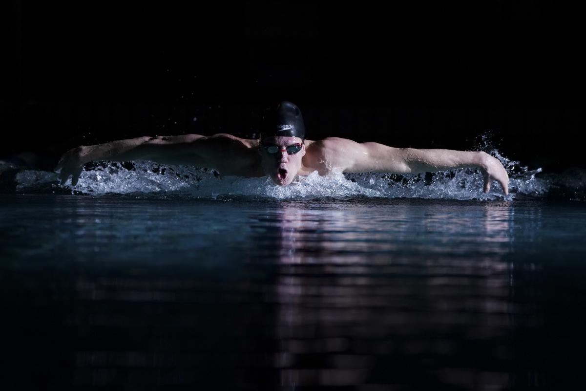 Male swimmer in water, warms outstretched in between a stroke 