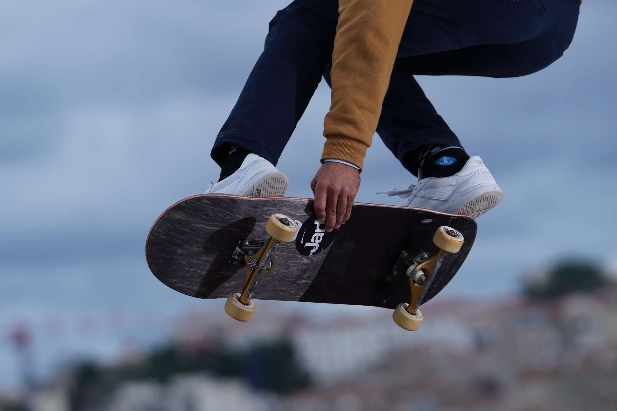 Close-up of skateboarder's feet while the board is tilted in the air mid-jump
