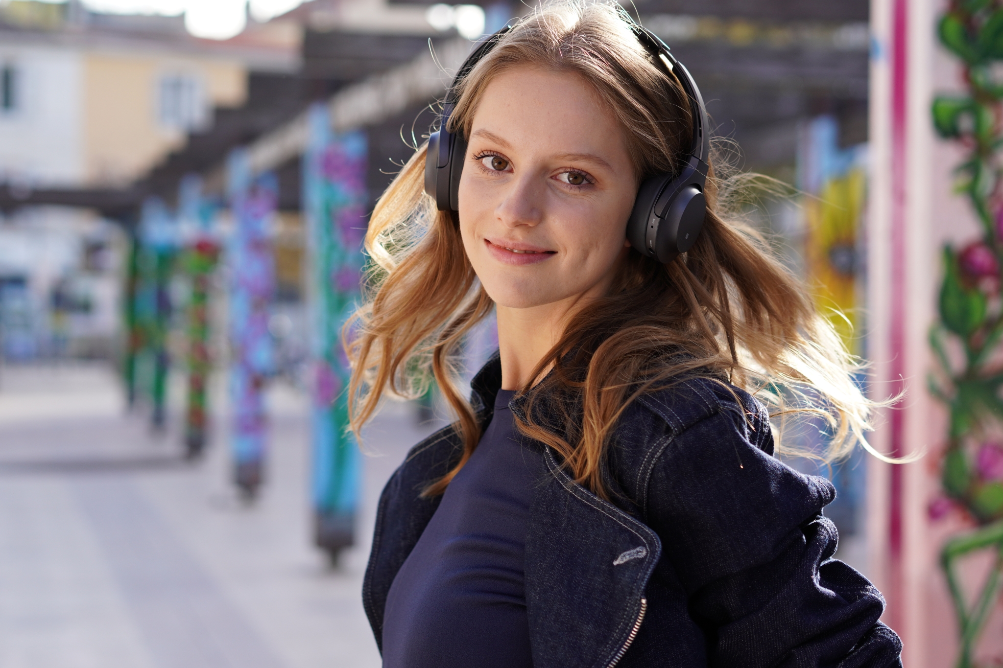 Portrait of female model standing outside wearing headphones