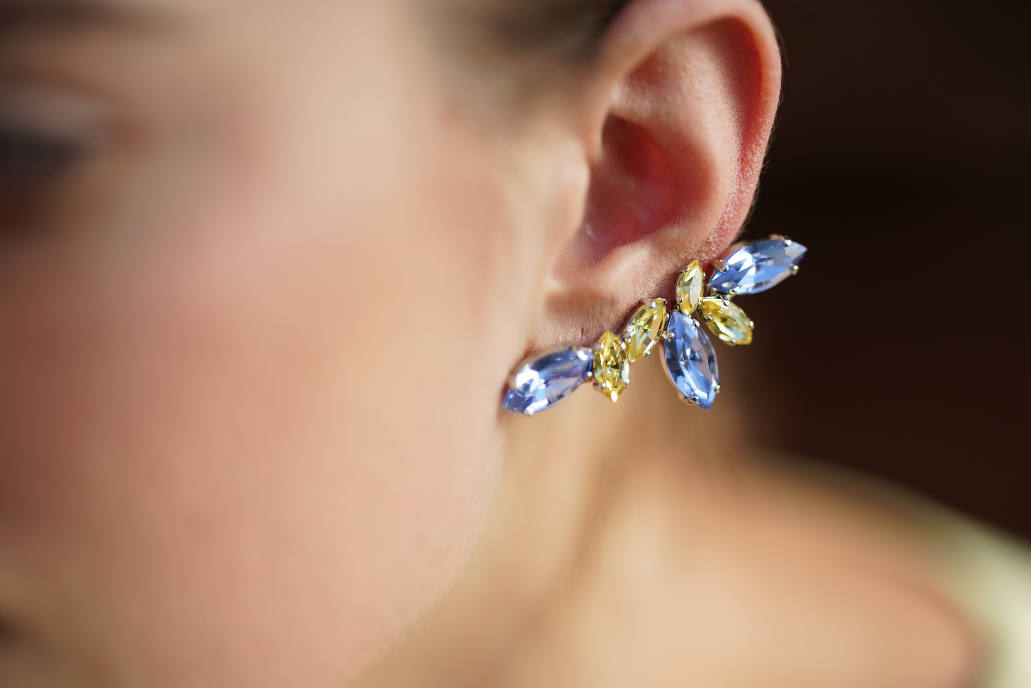 Close-up of a gemstone earring in a woman's ear