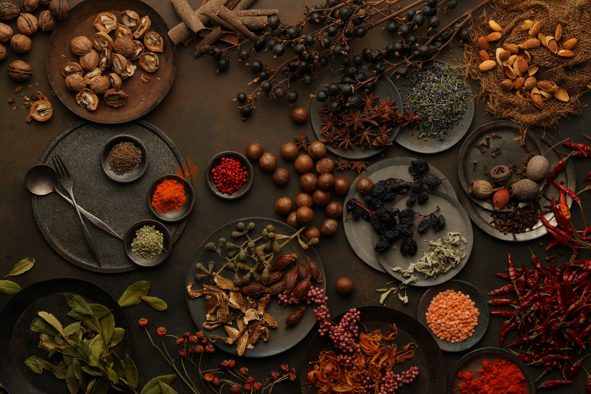 Aerial shot of fruits, nuts and spices spread on a table, some on plates