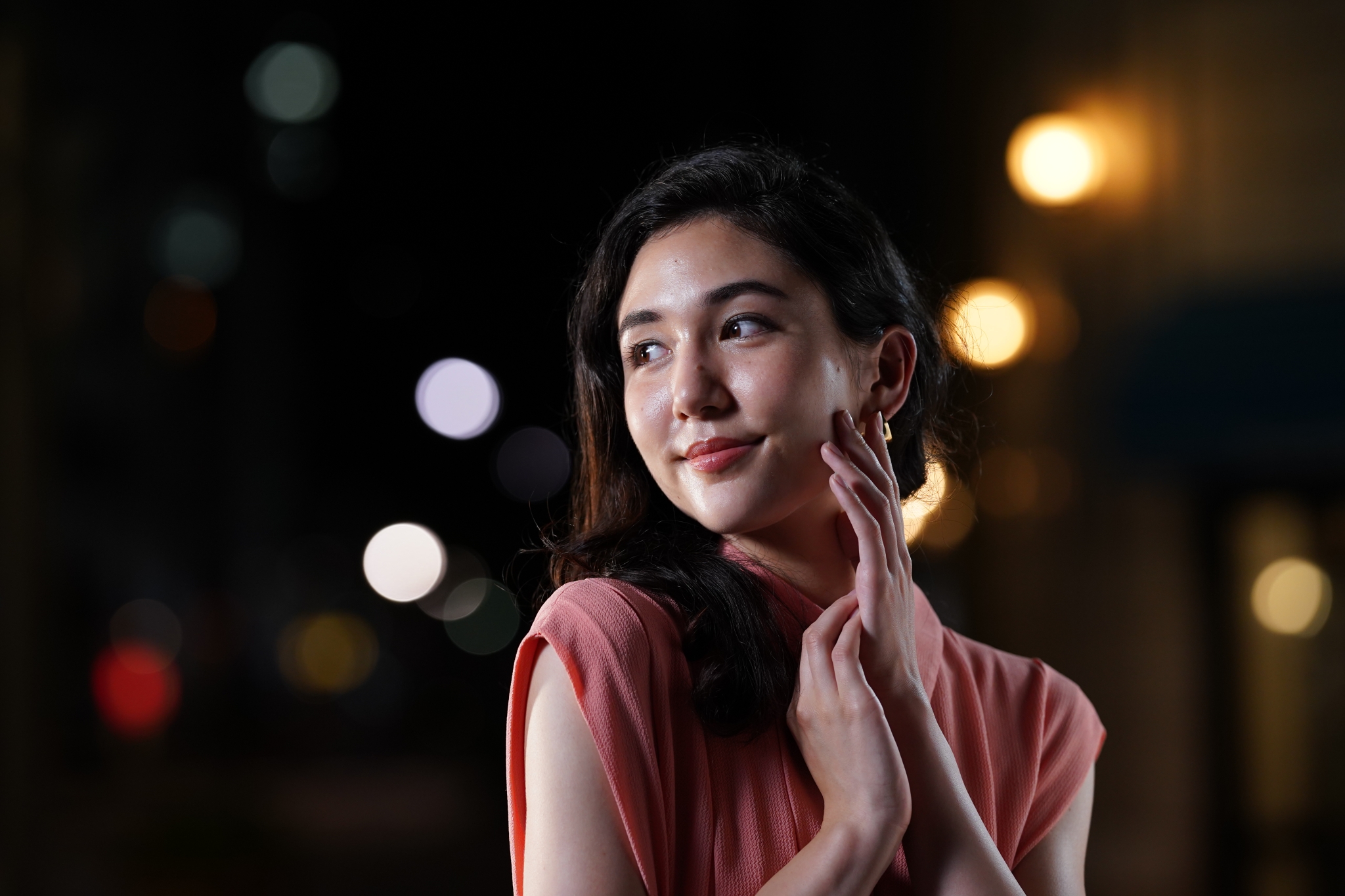 Female model at night-time with streetlights in bokeh background