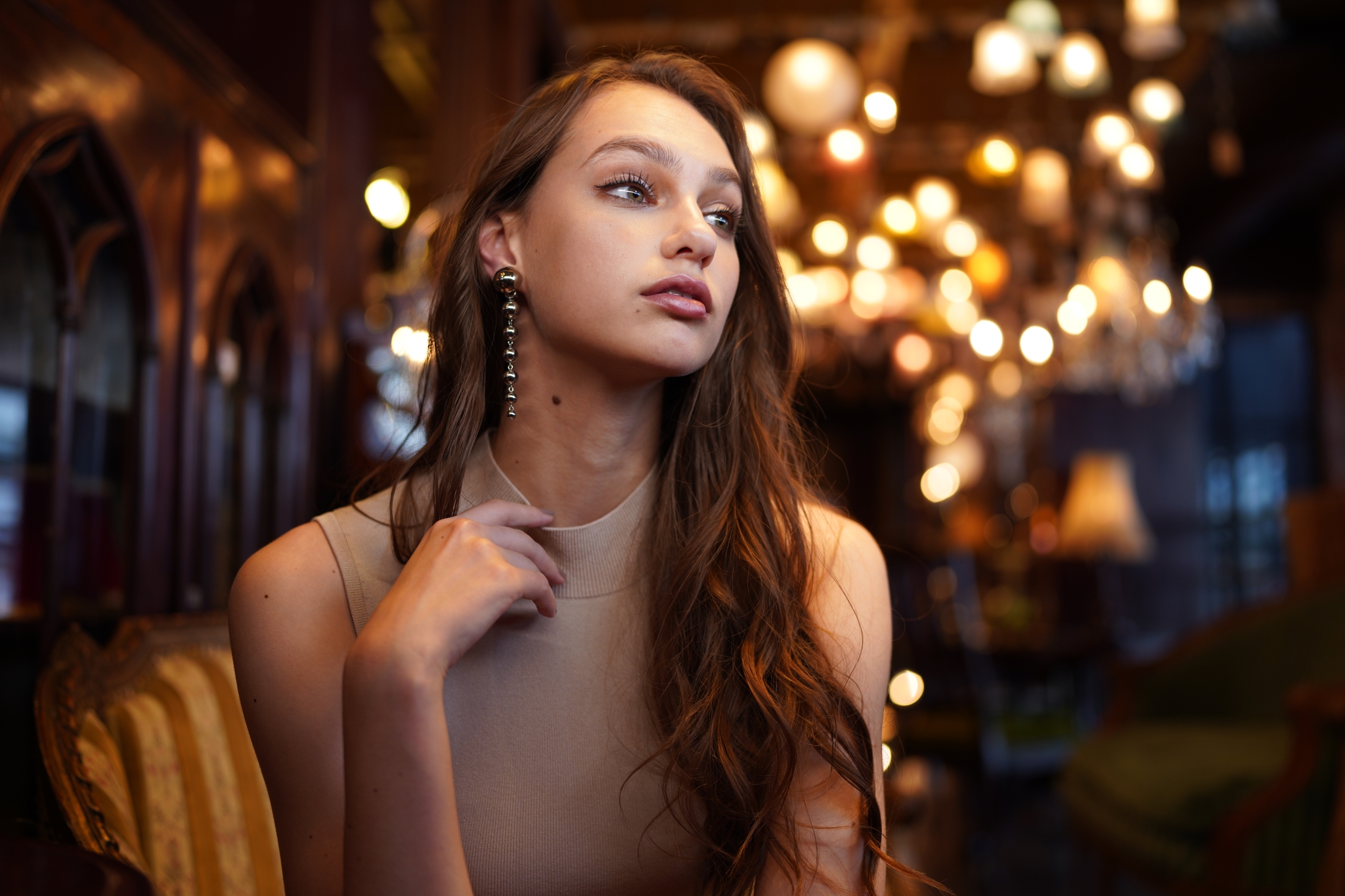 Portrait of female model looking to her left with interior lights in bokeh background
