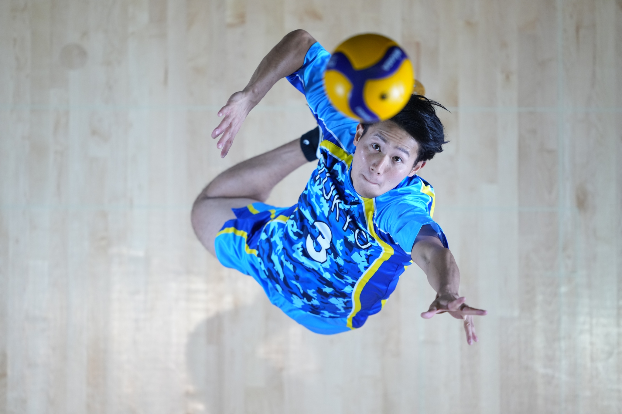 Aerial shot of volleyball player jumping for ball above his head