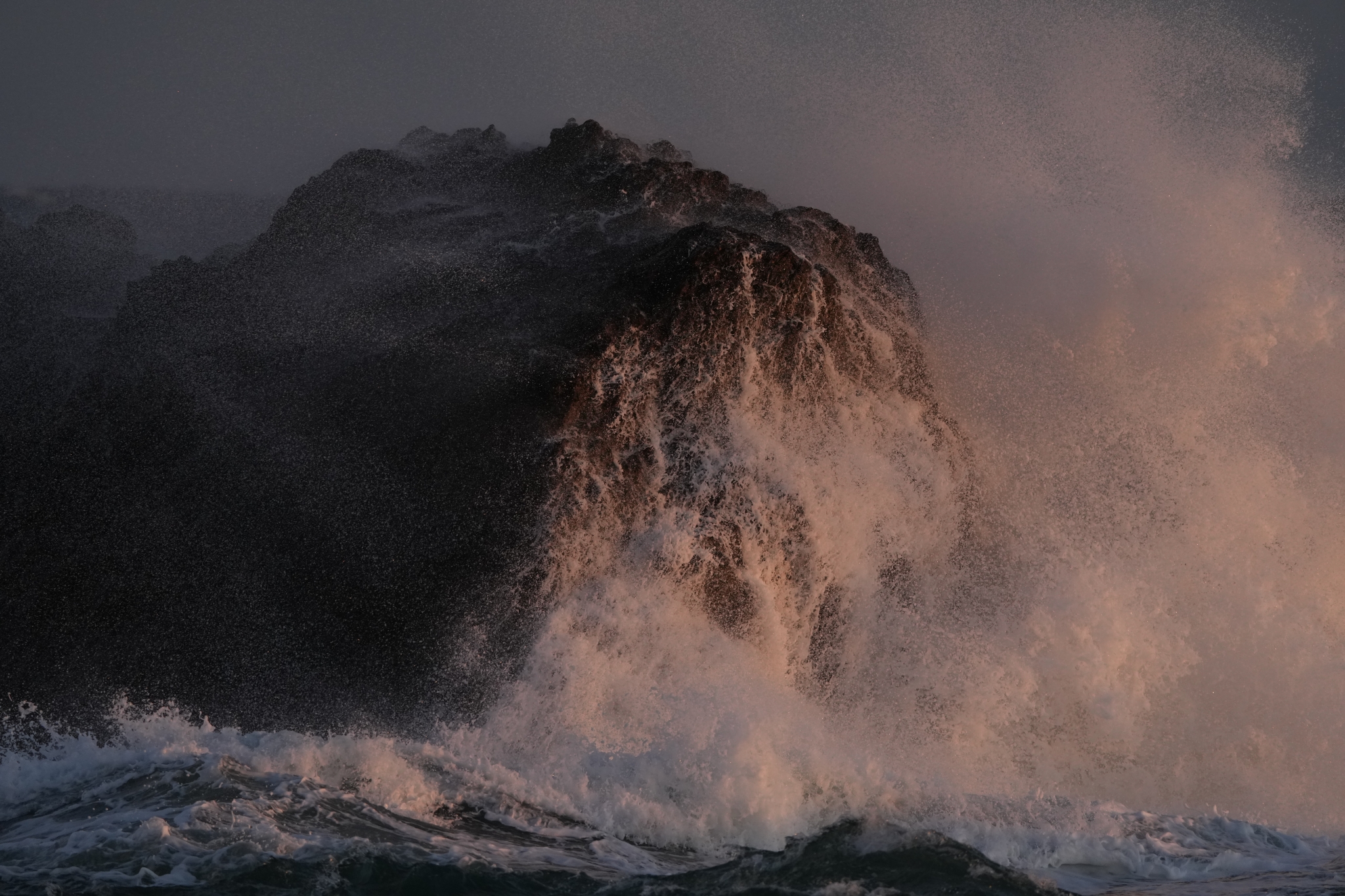 Waves breaking against a large rock