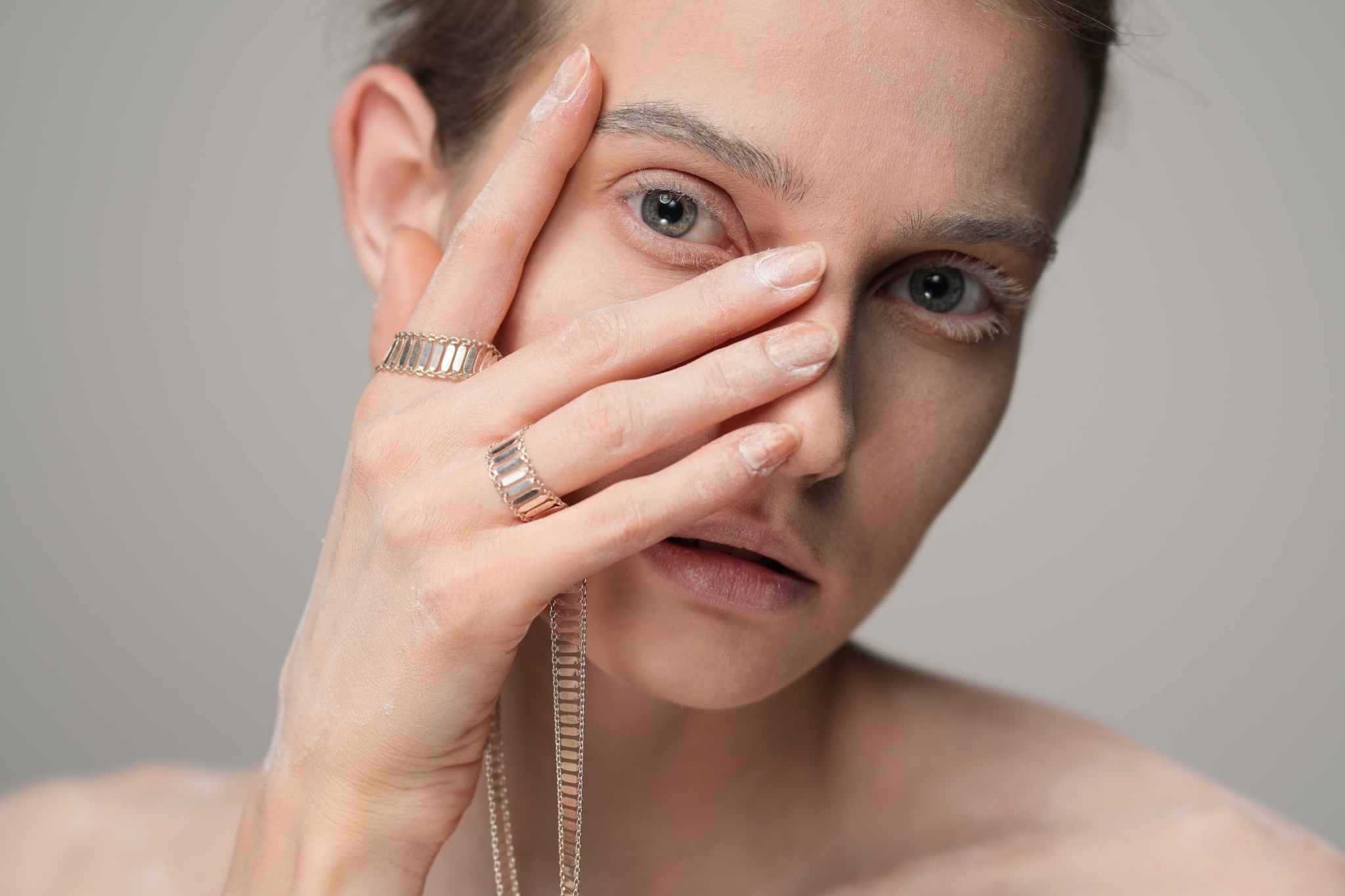 Portrait of female model looking through her fingers
