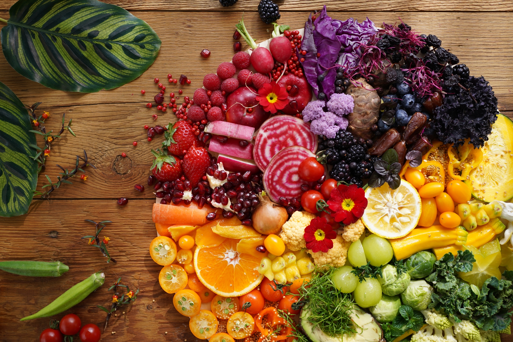 Fruit and vegetables arranged in a colourful circle on a wooden table