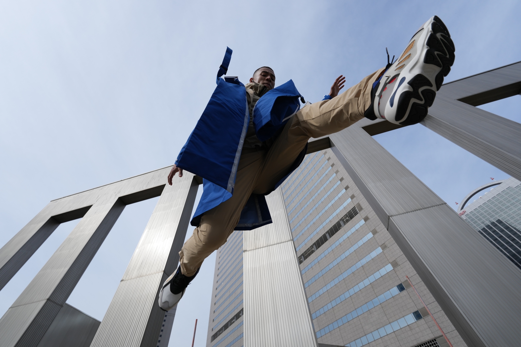Upward shot of a person in mid-leap in front of a building