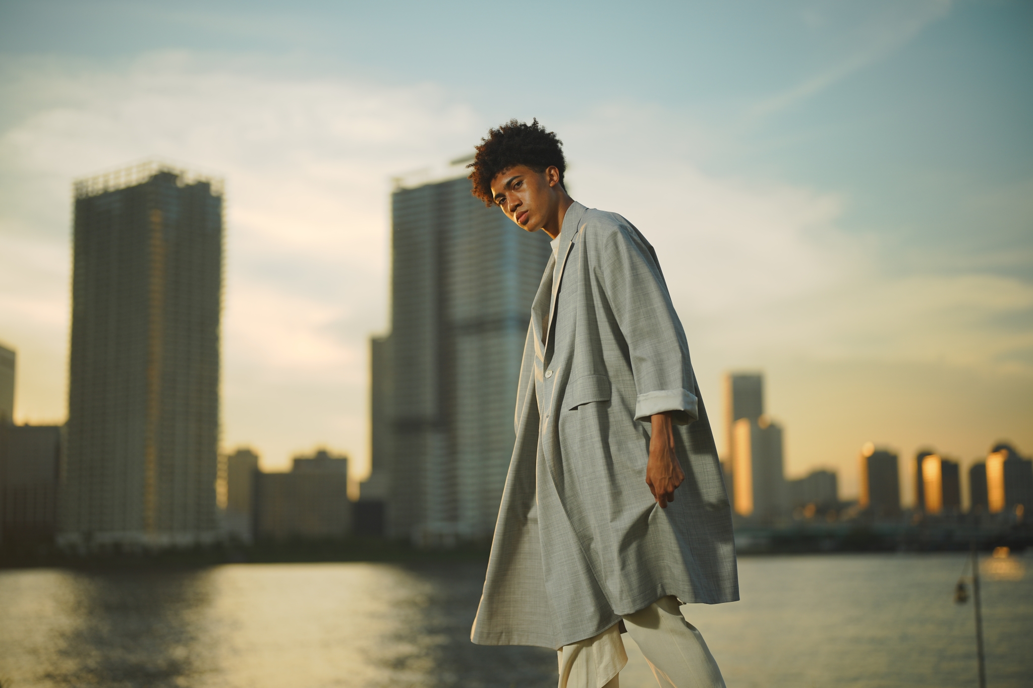 Male model with cityscape by water in the background