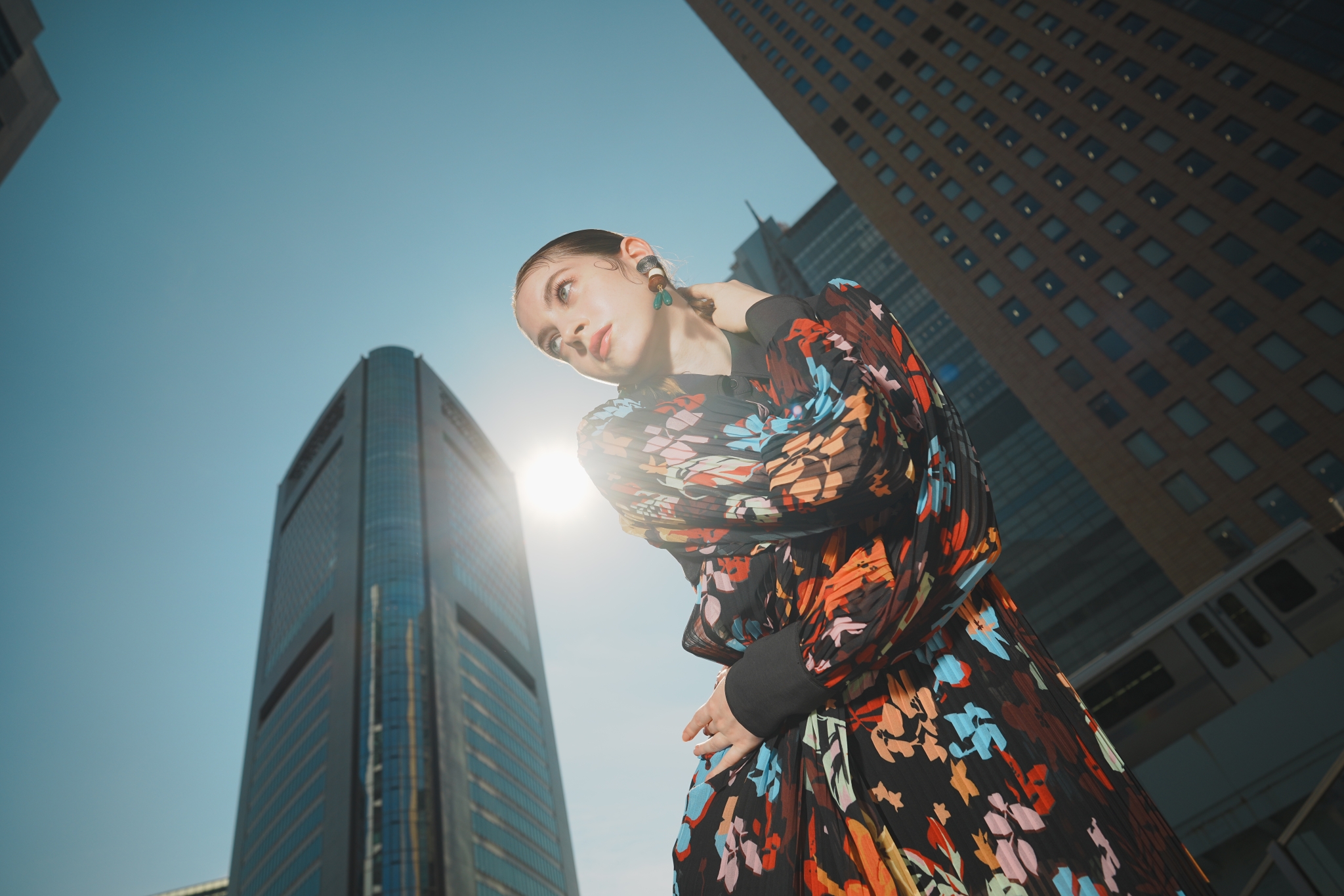 Female model with skyscrapers and sun in the background