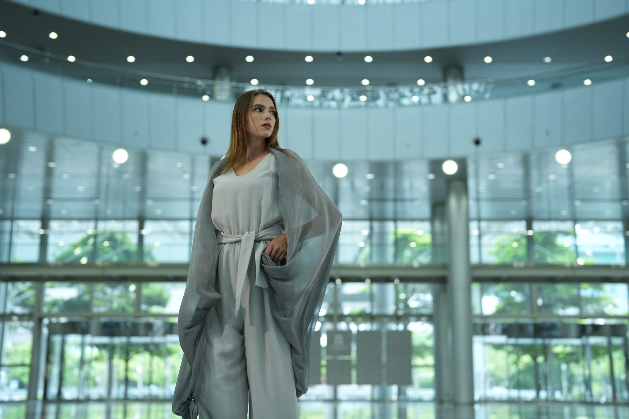 Female model in a curved room with glass walls
