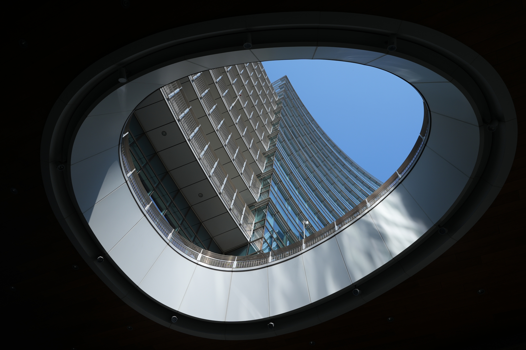 Rounded roof with a hole open to the sky and view of a tall building