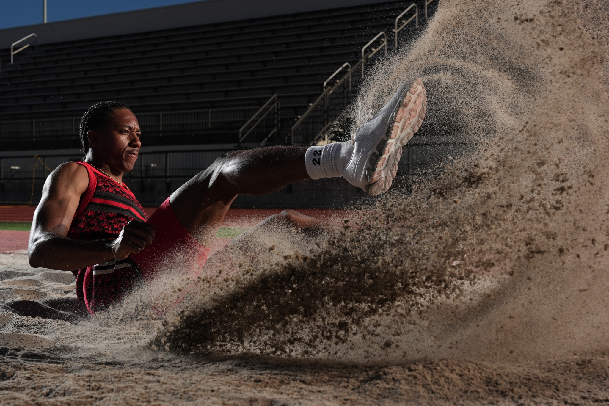Male athlete skidding in the sand