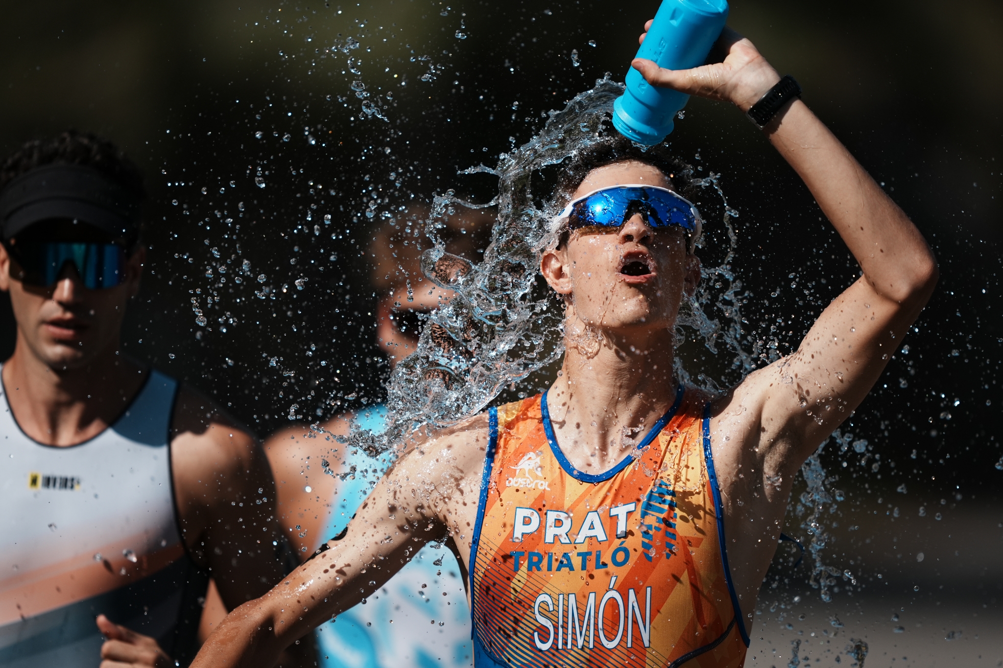 Male athlete pouring water over his head to cool down