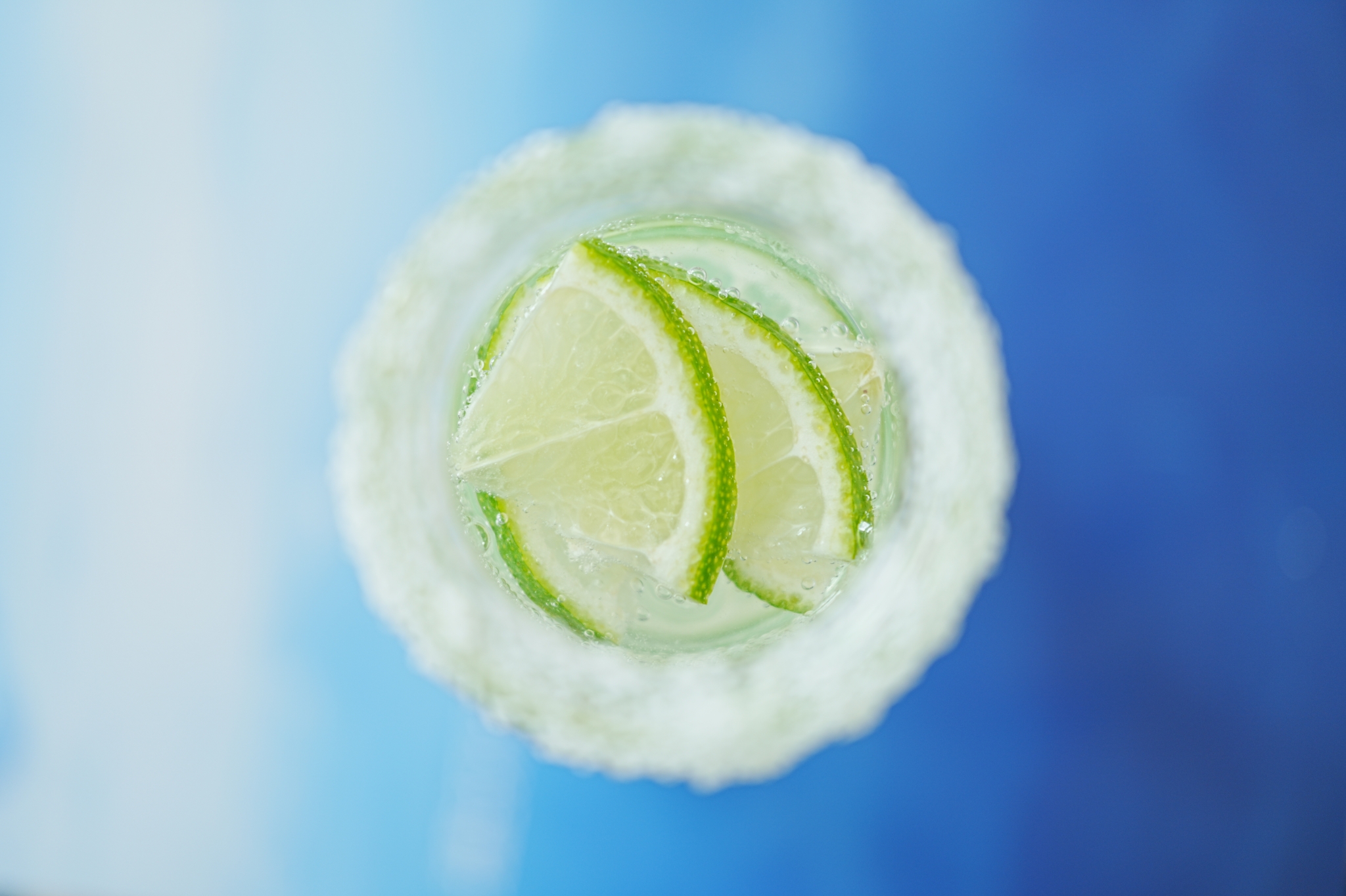 Arial shot of slices of lime on top of a margarita cocktail with a shallow depth of field
