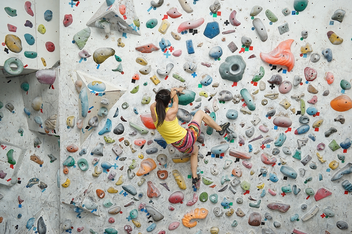 Female climber scaling bouldering wall