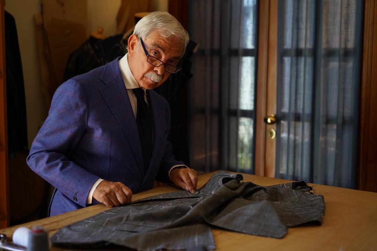 Portrait of suited tailor working on cloth