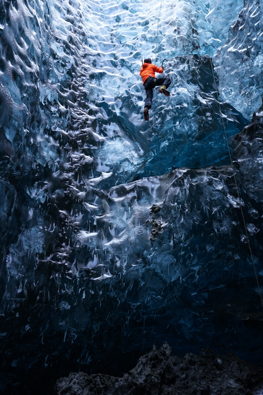 Man climbing wall in ice cave
