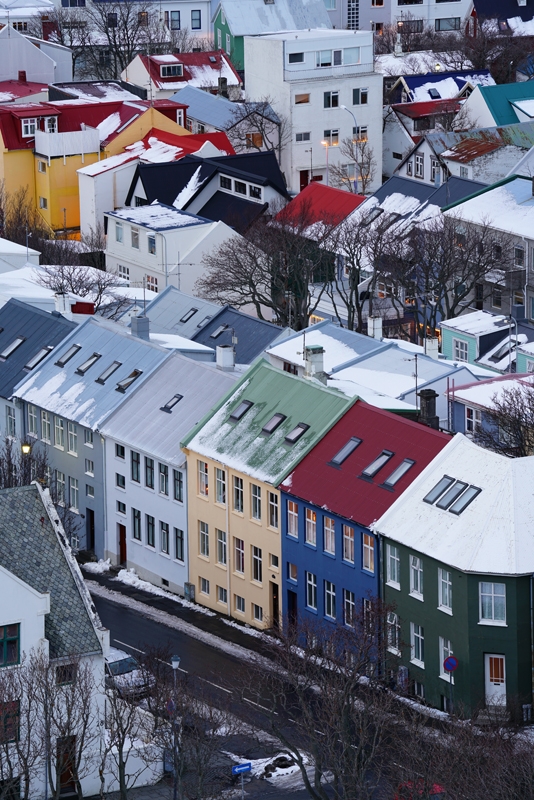 Aerial shot of town with snow on multi-coloured rooves