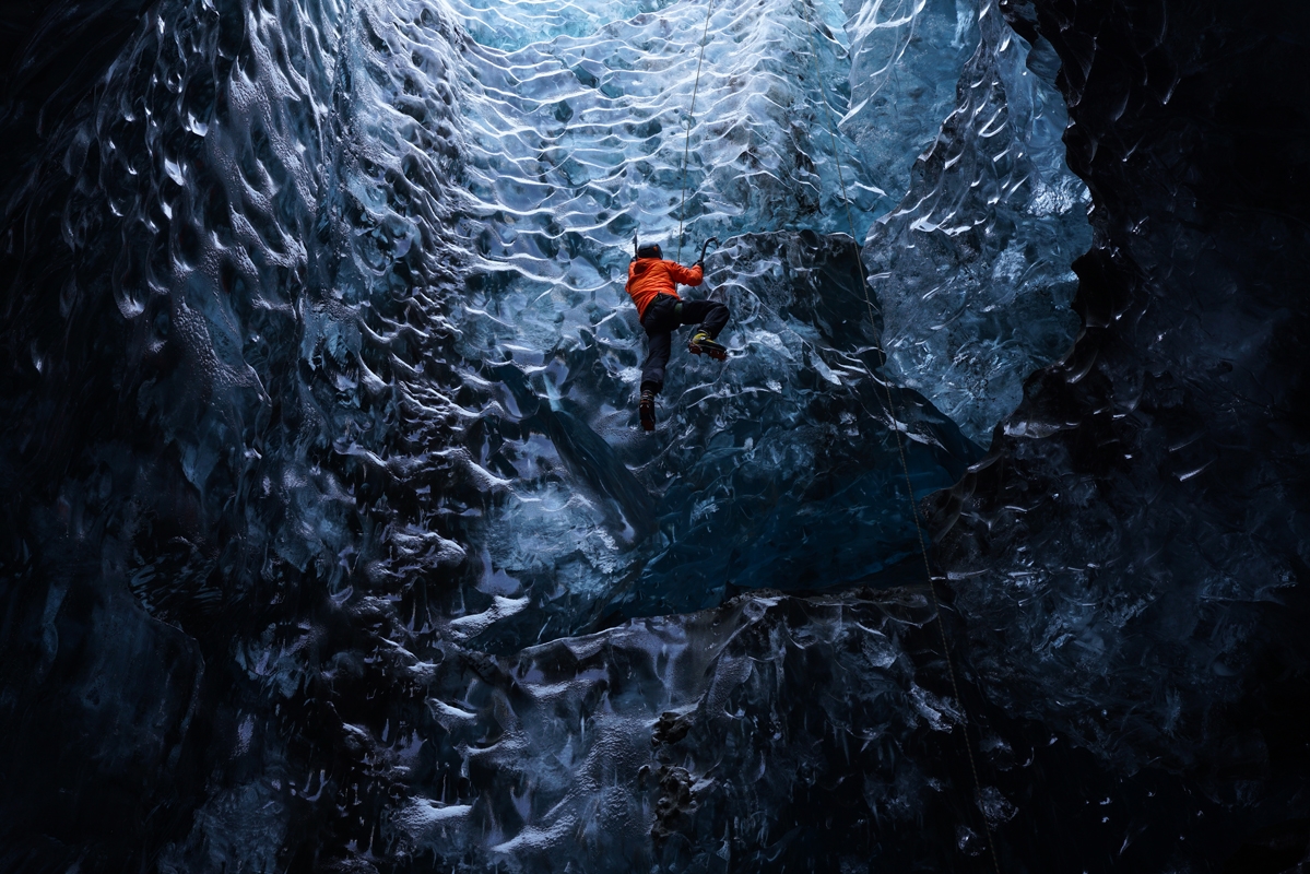 Man climbing wall in ice cave