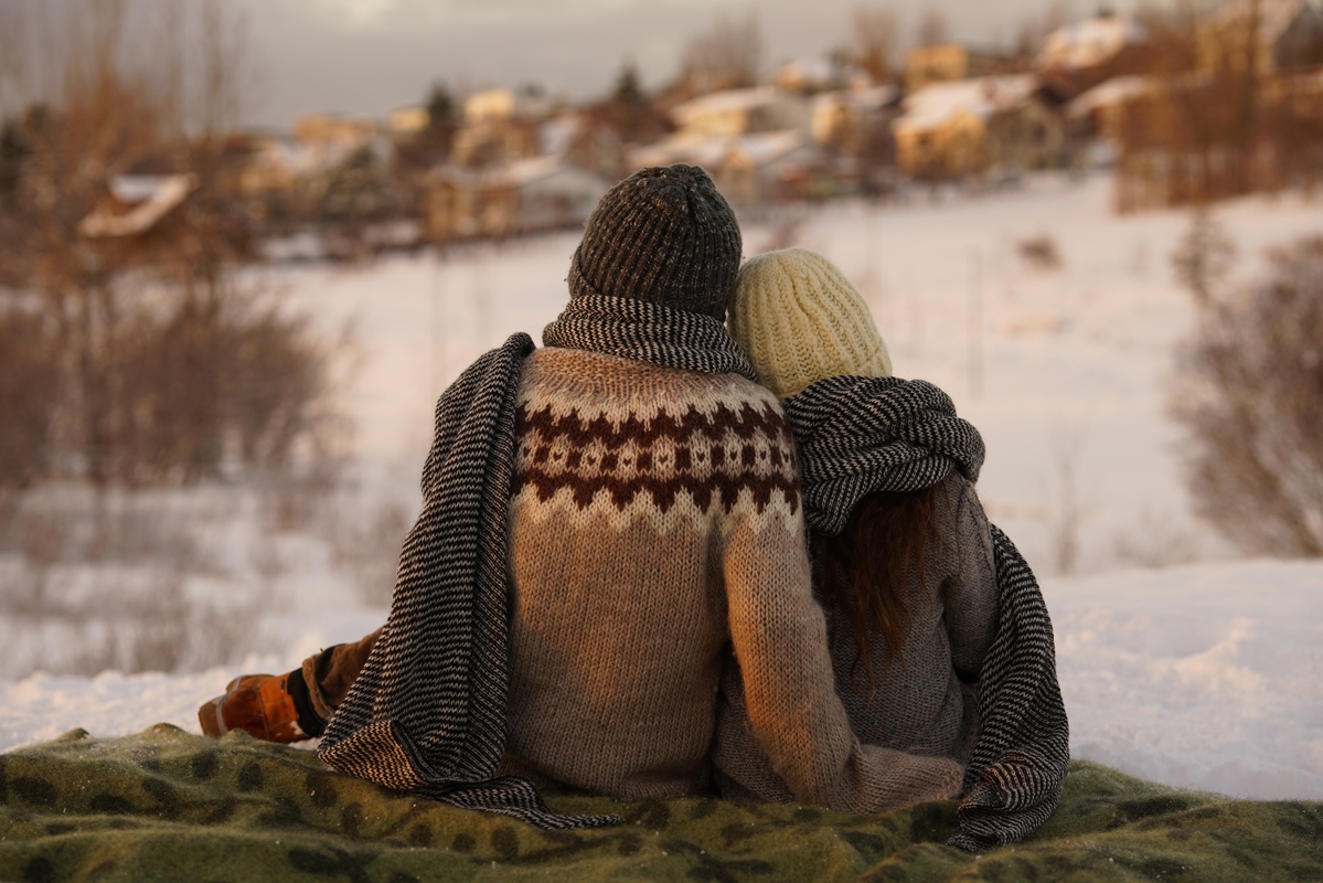 Shot from behind of couple sitting together in snowy location