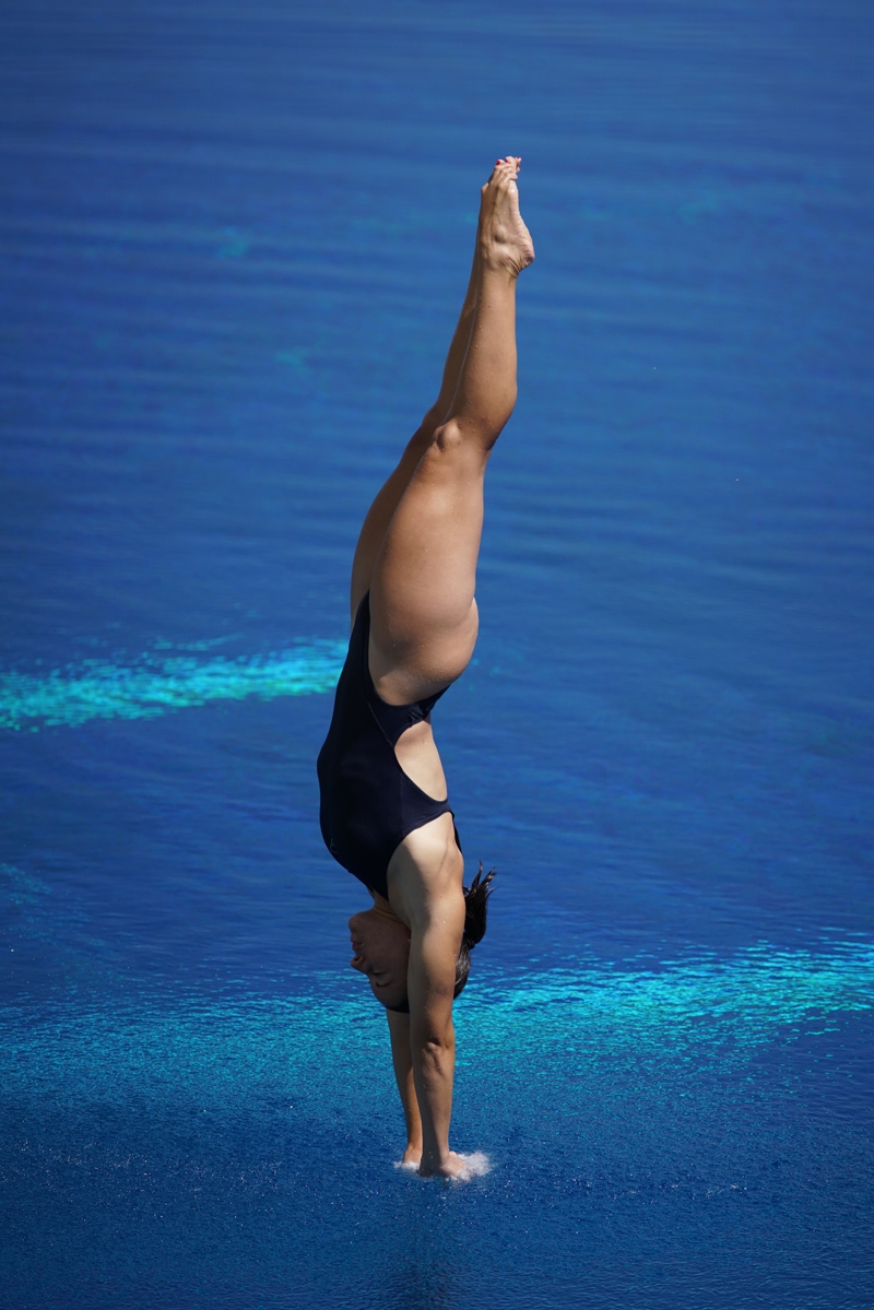 Diver at full stretch, about to enter water