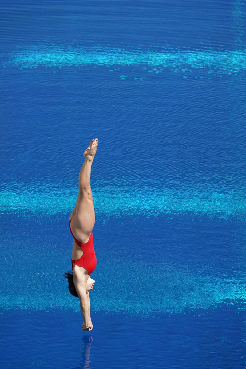 Diver at full stretch, about to enter water
