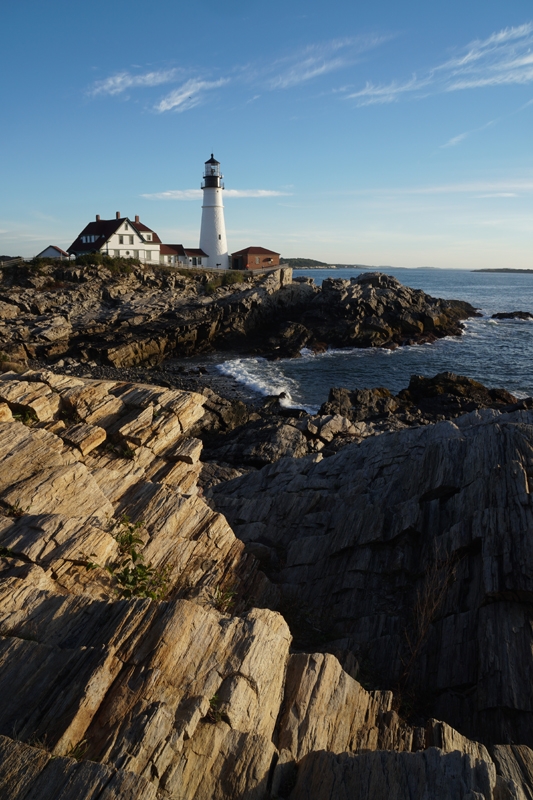 Coastal scene with lighthouse, ocean and rock formations