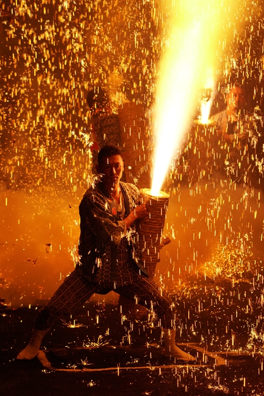Man holding firework torch spitting sparks at fire festival