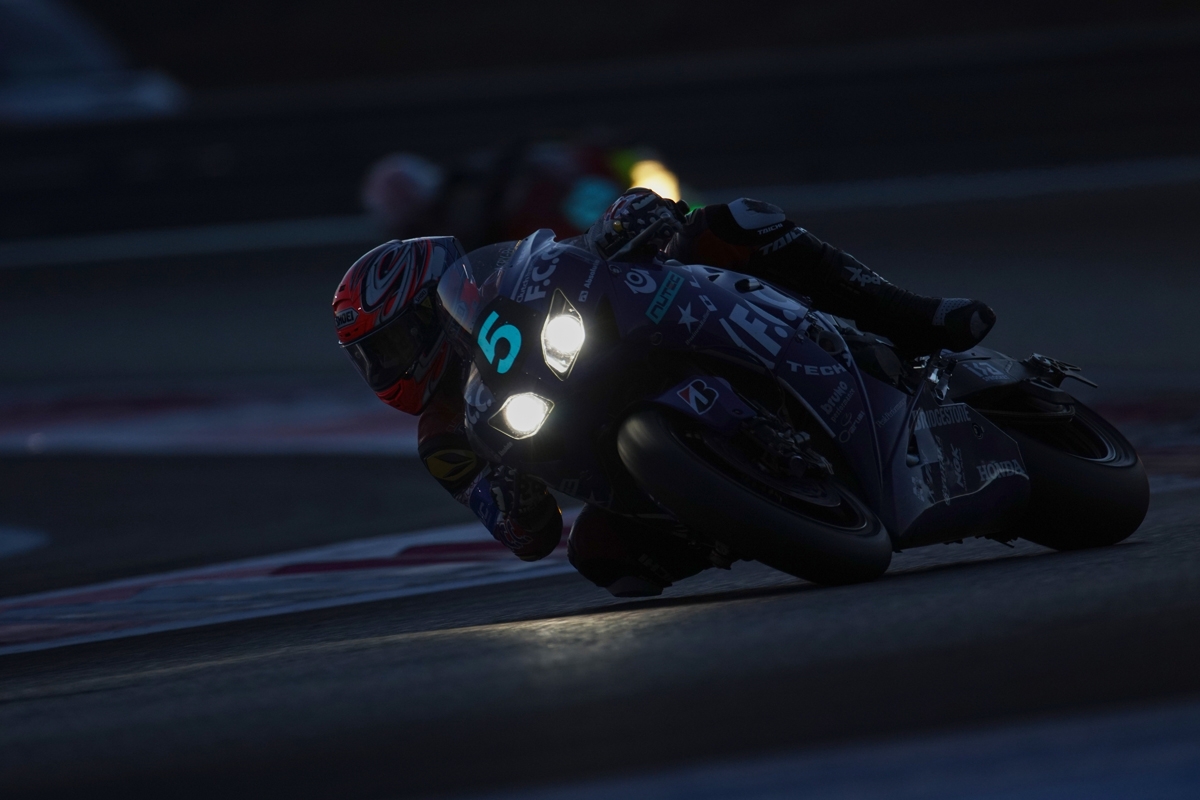 Motorcycle and rider in competition night practice with lights on