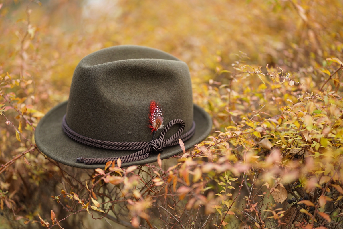 Felt hat lying on bush with foreground and background bokeh
