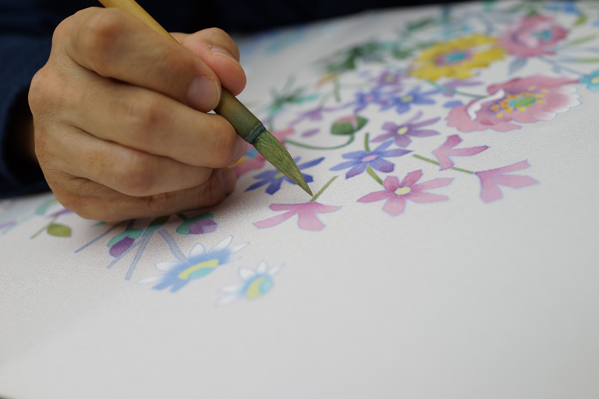 Person painting a floral design