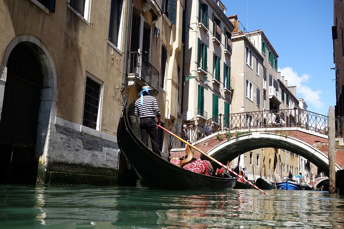 Shot from low position of Venetian canal scene with gondola and gondolier