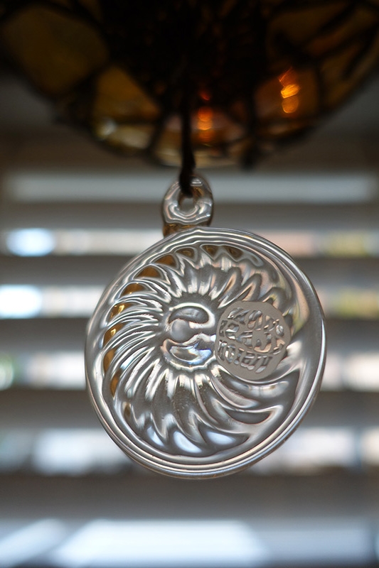 Close-up of glass necklace ornament against background bokeh
