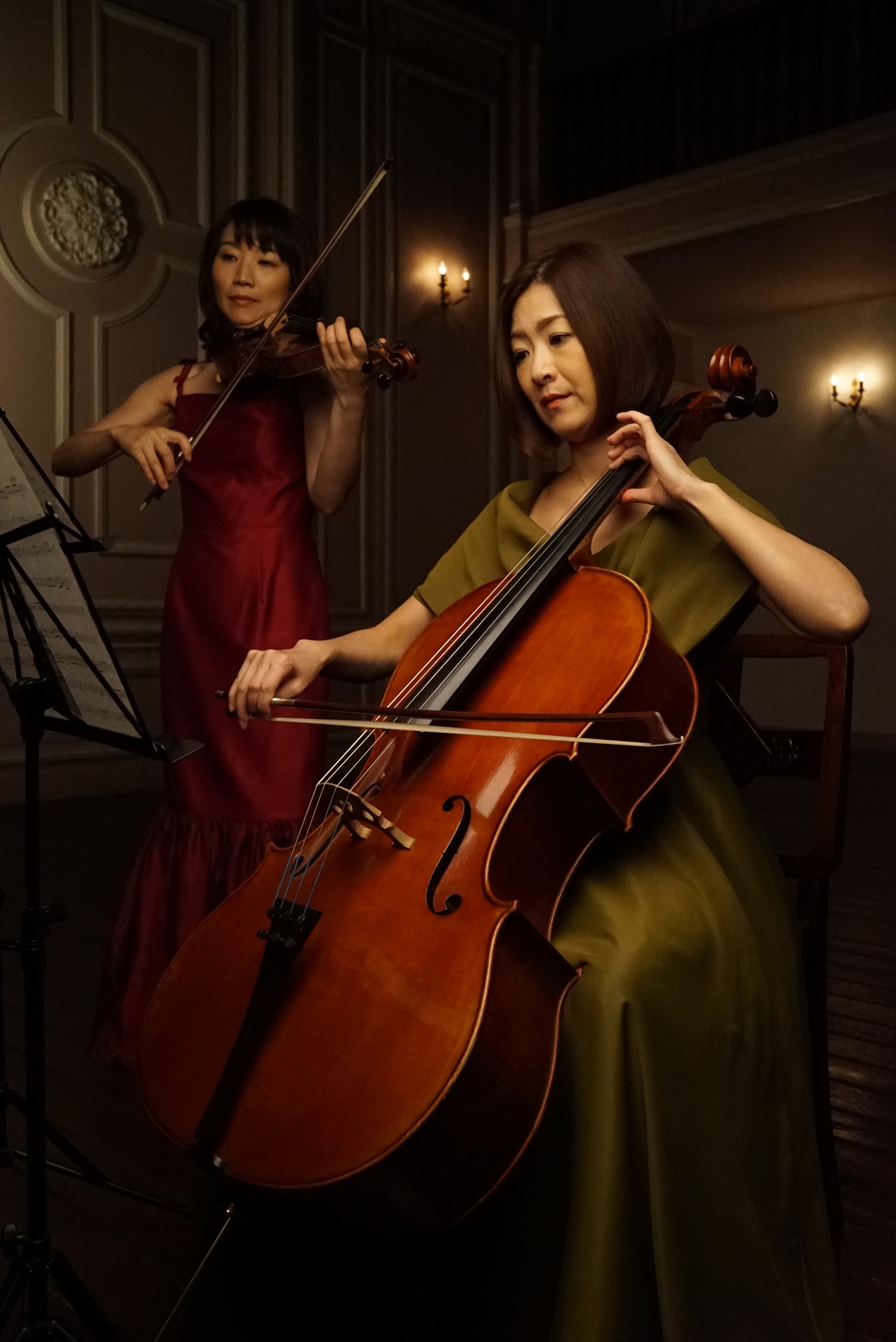 Female cello and violin players performing in low light