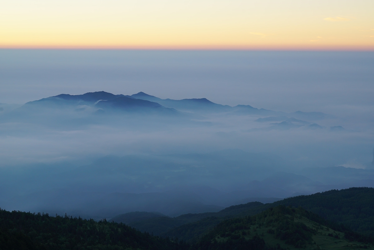 Shot from above low clouds surrounding mountain top