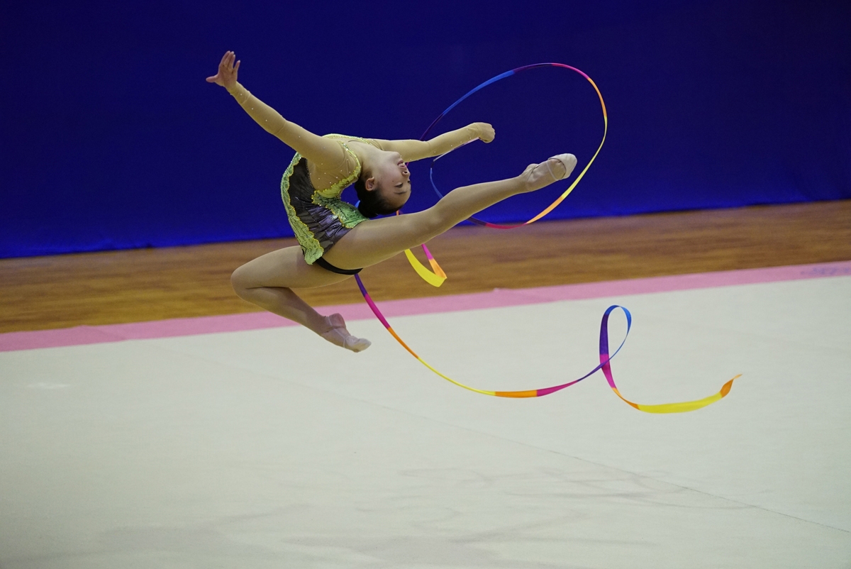 Female gymnast performing with streamer