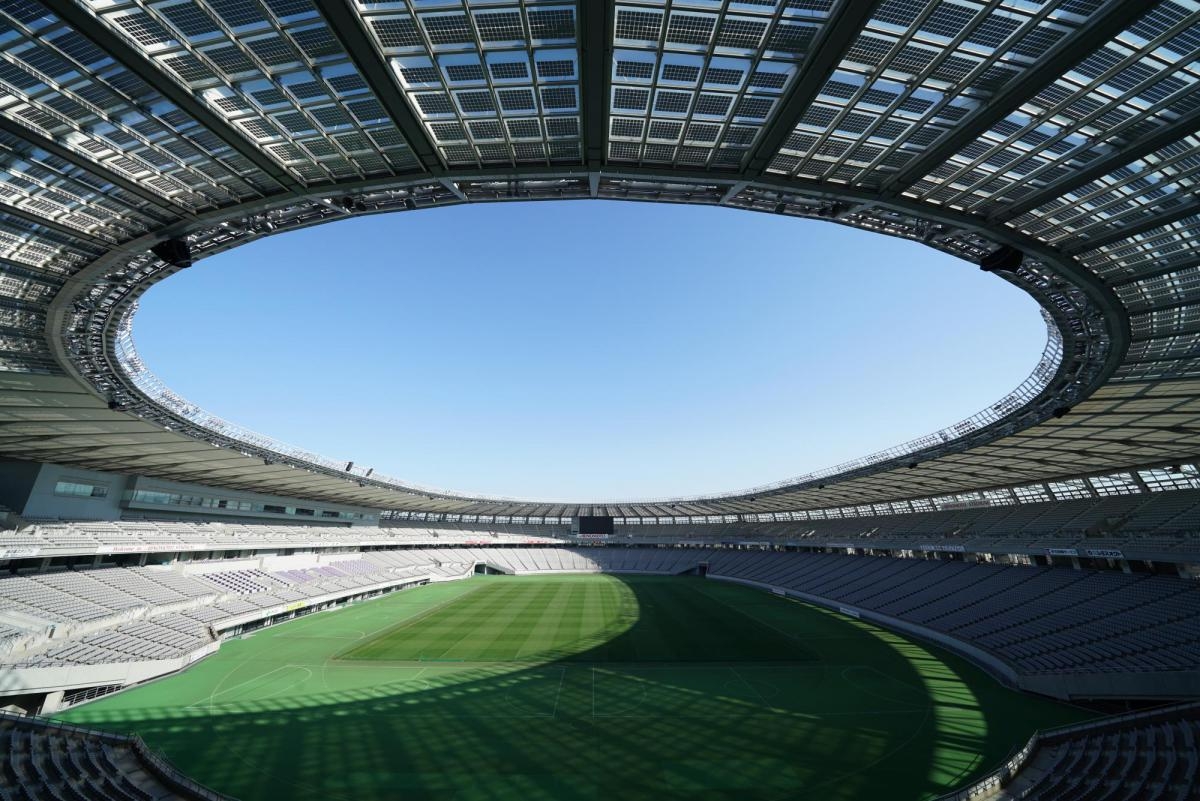 Sports stadium with grass pitch and round open roof