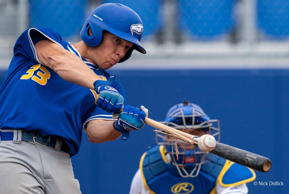 Left-handed baseball batter at the moment of striking the ball