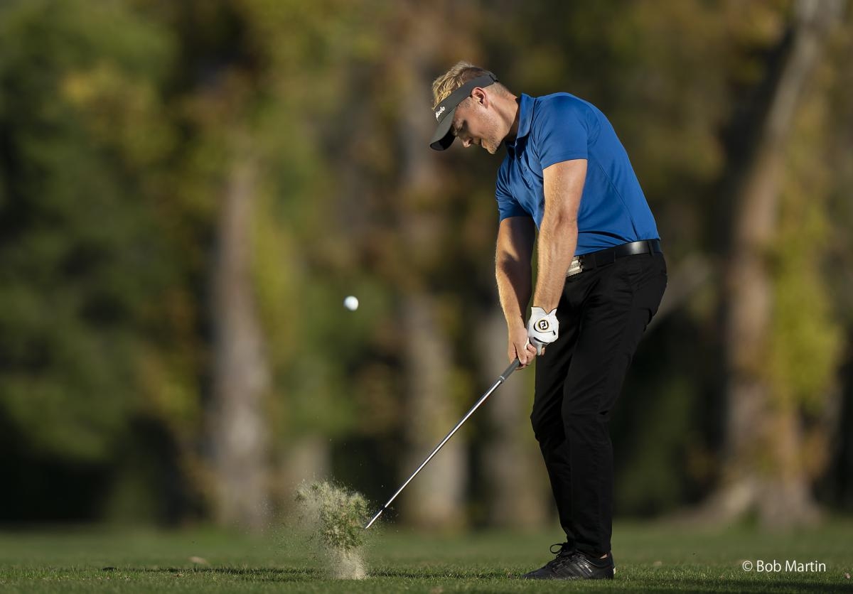 Golfer moments after striking the ball toward the camera