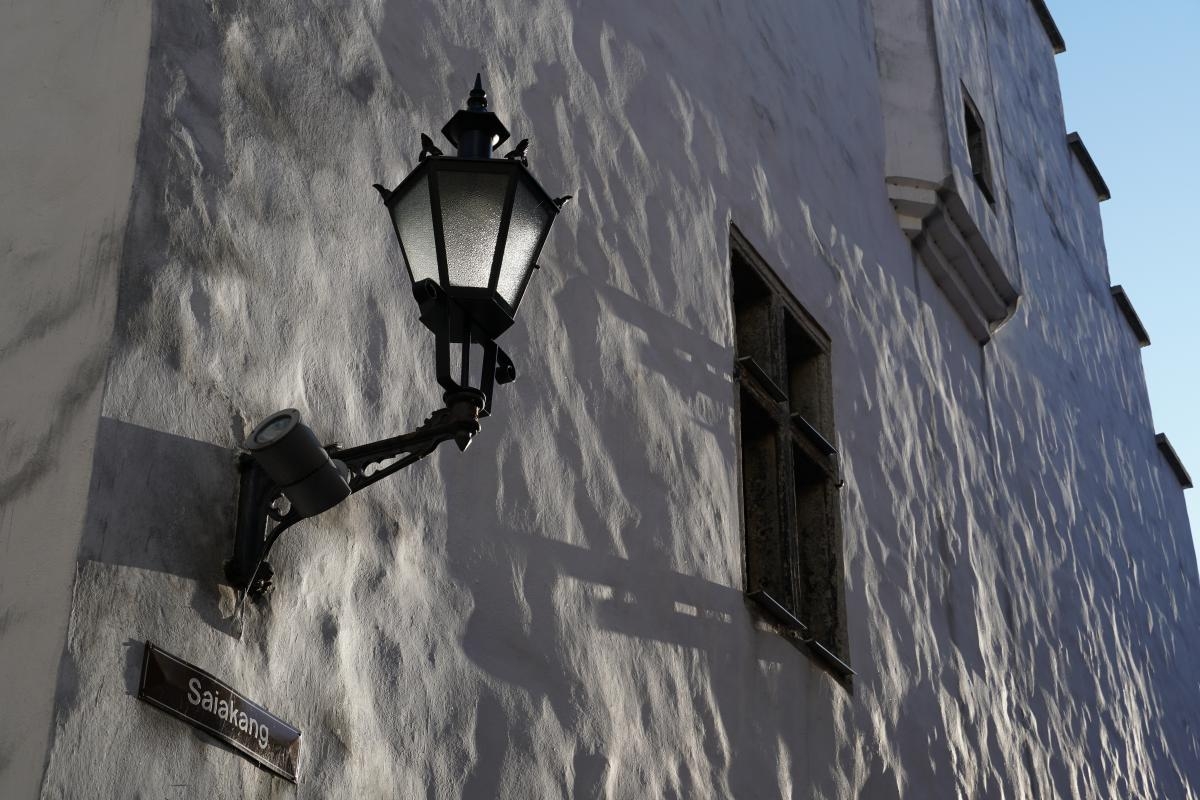 Lamp and streetname sign on side of building